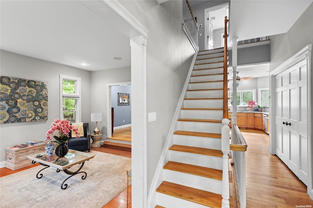 stairs with plenty of natural light and wood-type flooring