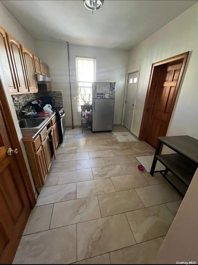 kitchen featuring backsplash, stainless steel fridge, and sink