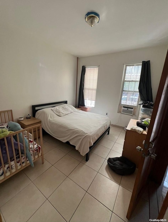 bedroom with cooling unit and light tile patterned floors