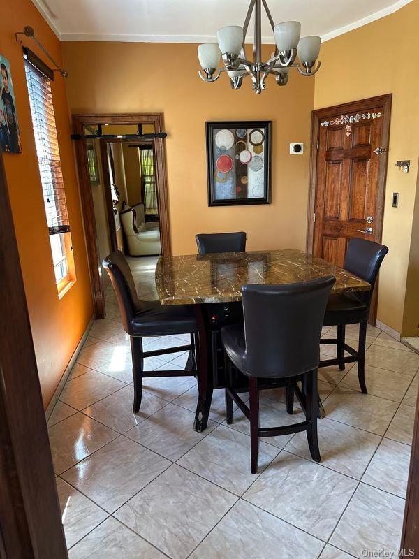 303 Milford St, Brooklyn, NY 11208 - dining area featuring a chandelier and crown molding