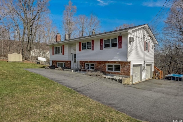 split foyer home featuring a garage and a front lawn