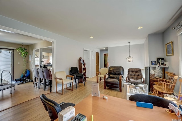 living room featuring light wood-type flooring and an inviting chandelier