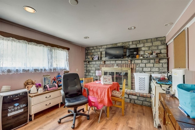 dining room featuring light wood-type flooring and a fireplace