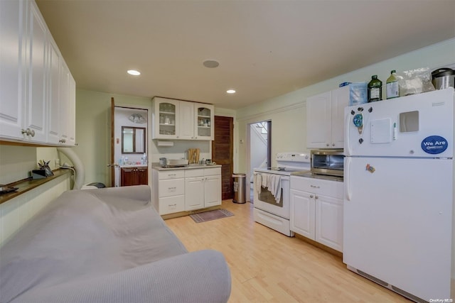 kitchen with white cabinets, white appliances, and light hardwood / wood-style flooring