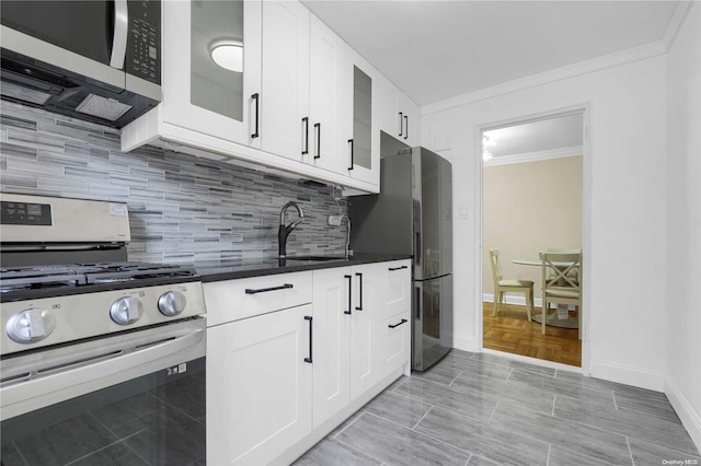 kitchen with backsplash, sink, white cabinets, and appliances with stainless steel finishes