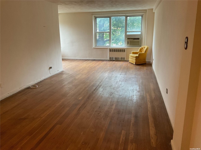 unfurnished room with radiator, cooling unit, wood-type flooring, and a textured ceiling