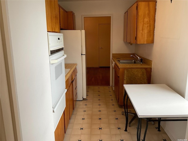 kitchen featuring white appliances and sink