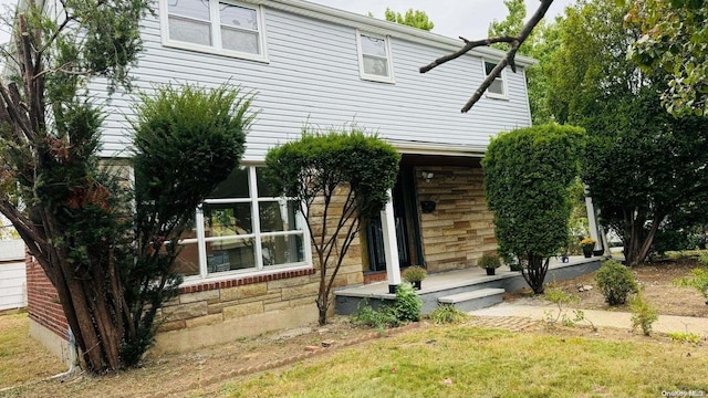 2041 New Hyde Park Rd, New Hyde Park, NY 11040 - view of property hidden behind natural elements with stone siding and a front lawn