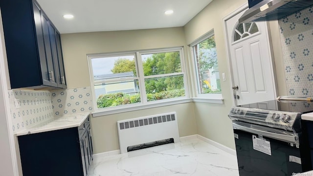 2041 New Hyde Park Rd, New Hyde Park, NY 11040 - kitchen with radiator heating unit, stainless steel electric range oven, blue cabinetry, decorative backsplash, and light stone countertops