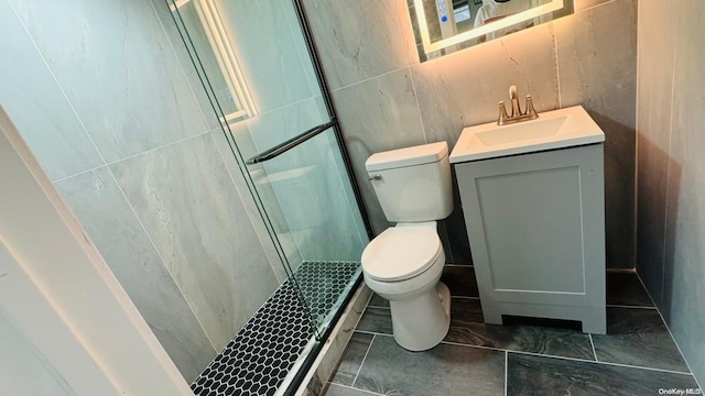 bathroom with vanity, an enclosed shower, tile walls, and toilet