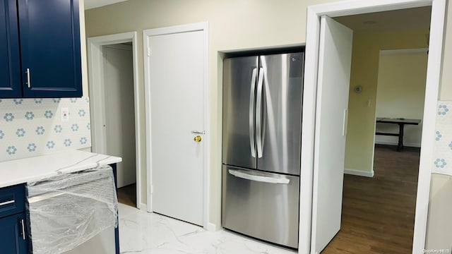 kitchen featuring light wood-type flooring, stainless steel refrigerator, and blue cabinets