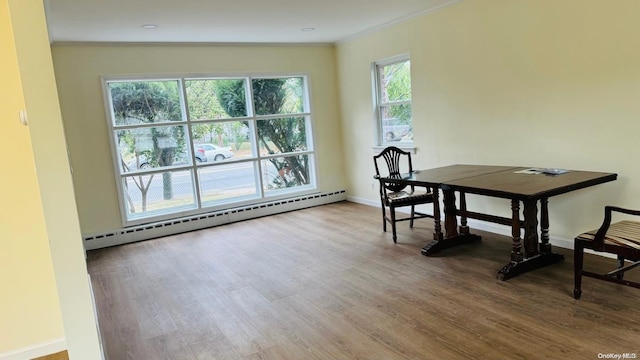 dining space featuring wood-type flooring, a baseboard radiator, vaulted ceiling, and ornamental molding