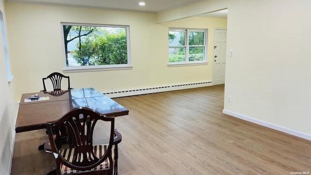 office area featuring plenty of natural light, light hardwood / wood-style flooring, and a baseboard heating unit