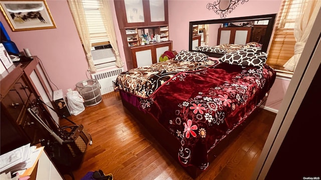 bedroom featuring wood-type flooring and radiator heating unit