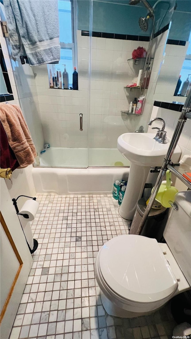 bathroom with tile patterned flooring, toilet, and enclosed tub / shower combo