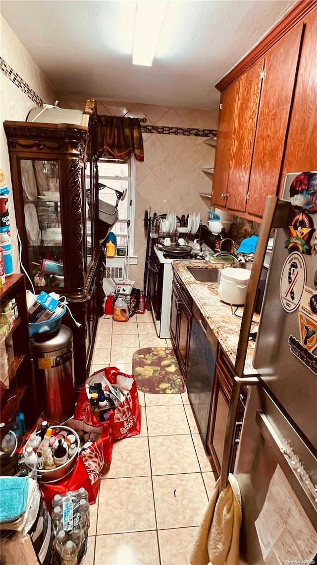 kitchen featuring light tile patterned floors, black dishwasher, and sink