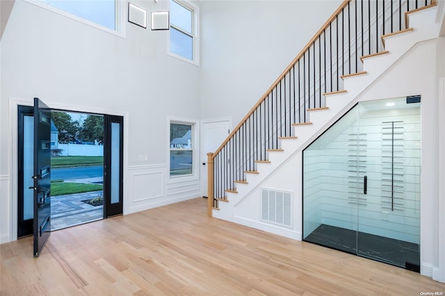 foyer featuring a towering ceiling and light wood-type flooring