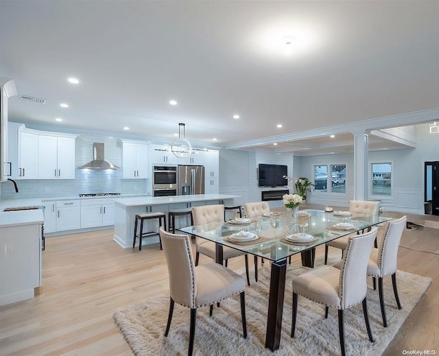 dining space with a chandelier, light wood-type flooring, and sink