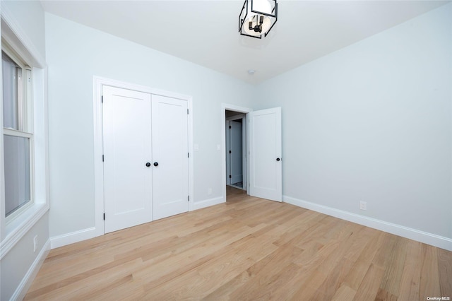 unfurnished bedroom with light hardwood / wood-style floors and a closet