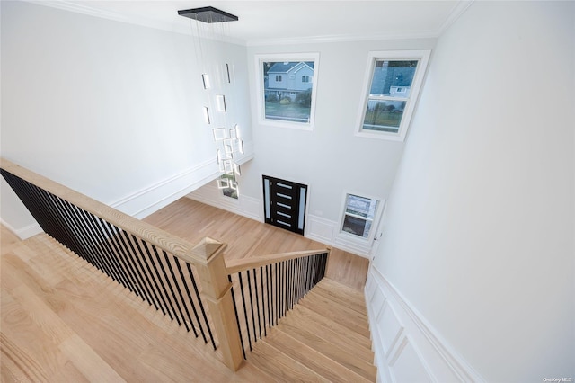 stairway featuring wood-type flooring and ornamental molding