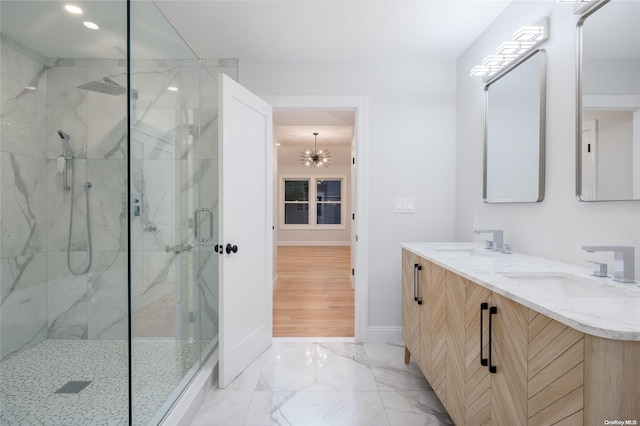 bathroom with hardwood / wood-style floors, vanity, a shower with shower door, and an inviting chandelier