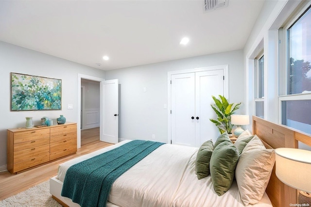 bedroom with a closet and light hardwood / wood-style flooring