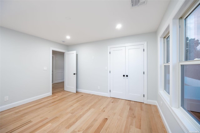 unfurnished bedroom featuring light hardwood / wood-style floors and a closet