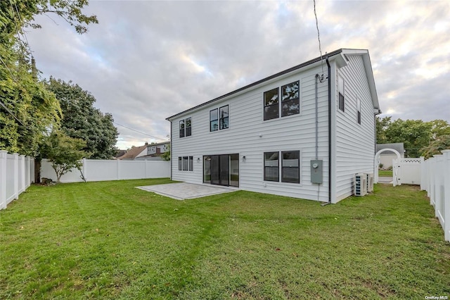 back of property with a yard and a patio area