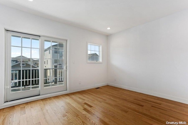 spare room with hardwood / wood-style floors and a healthy amount of sunlight