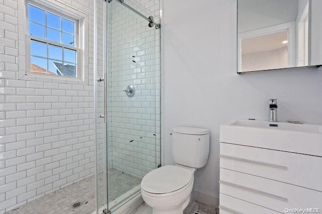 bathroom featuring vanity, toilet, and a shower with door