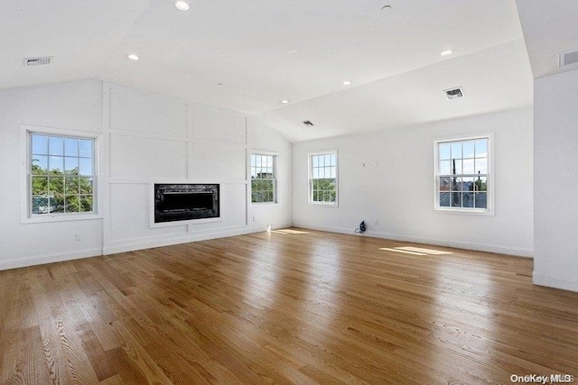 unfurnished living room featuring hardwood / wood-style floors and lofted ceiling