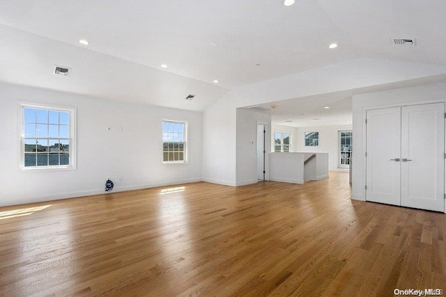 unfurnished living room featuring wood-type flooring and vaulted ceiling