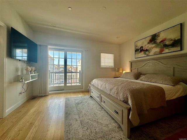 bedroom featuring access to exterior and light wood-type flooring