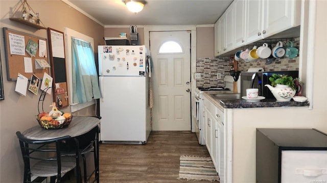 kitchen featuring backsplash, gas range, dark hardwood / wood-style floors, white fridge, and white cabinetry