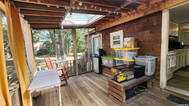 sunroom featuring lofted ceiling with skylight