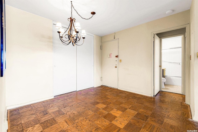 unfurnished dining area with dark parquet flooring and a notable chandelier