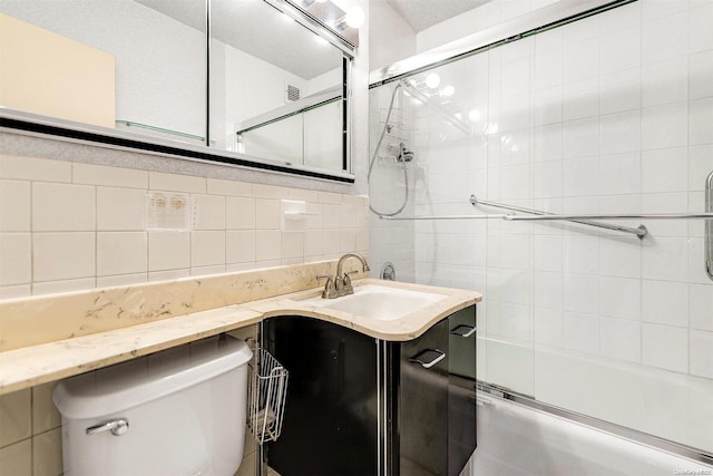 full bathroom with combined bath / shower with glass door, tile walls, backsplash, vanity, and toilet