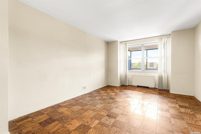 unfurnished room with light parquet flooring and radiator