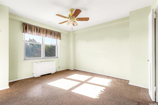 unfurnished room featuring radiator heating unit, ceiling fan, and carpet