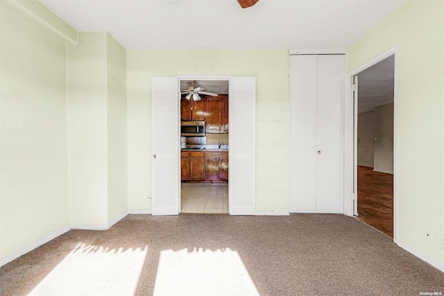 spare room featuring light carpet and ceiling fan