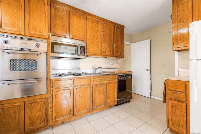 kitchen with stainless steel appliances, sink, and light tile patterned floors