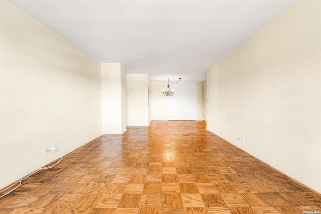 empty room featuring an inviting chandelier and light parquet floors