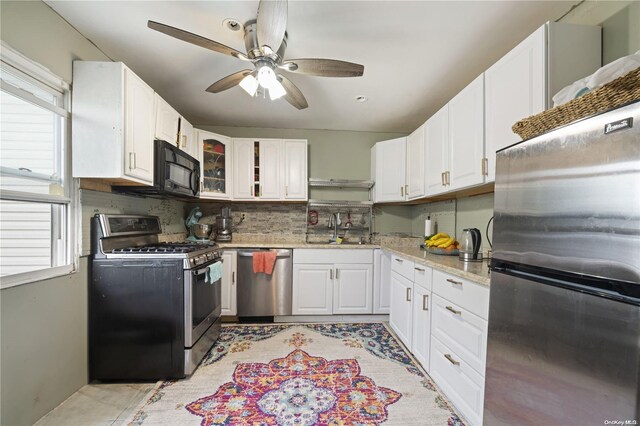 kitchen with stainless steel appliances, white cabinetry, a healthy amount of sunlight, and sink