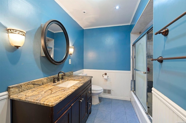 full bathroom featuring vanity, bath / shower combo with glass door, crown molding, tile patterned flooring, and toilet