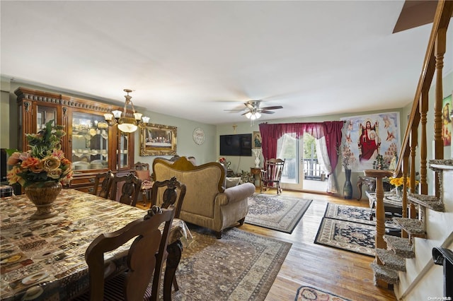 living room featuring hardwood / wood-style flooring and ceiling fan with notable chandelier