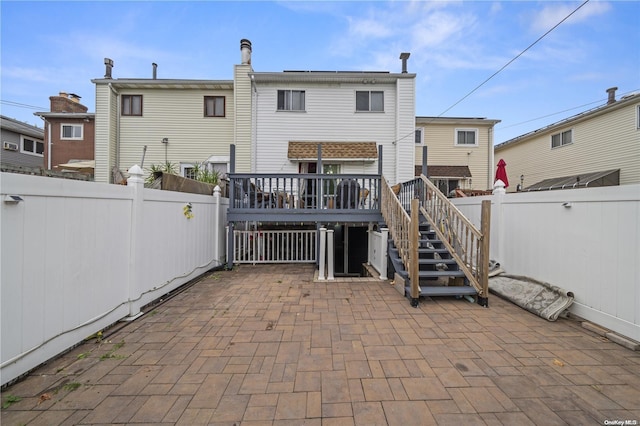 rear view of house featuring a deck and a patio