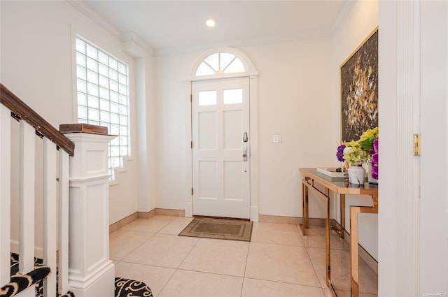 foyer featuring light tile patterned floors, plenty of natural light, and crown molding