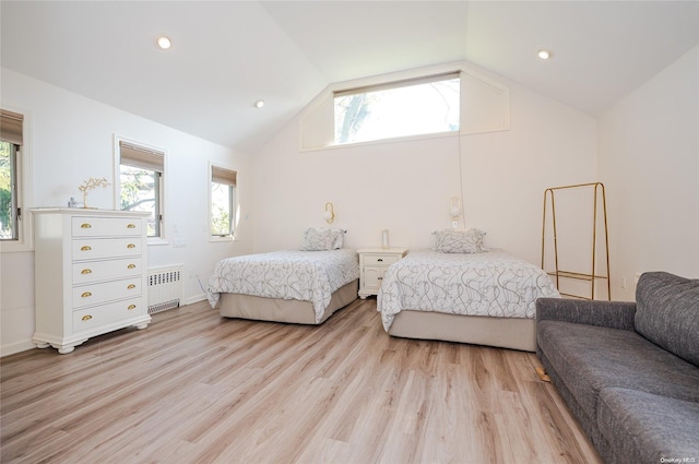 bedroom with radiator heating unit, light hardwood / wood-style flooring, and lofted ceiling