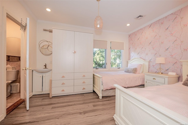 bedroom featuring light hardwood / wood-style floors, sink, and crown molding