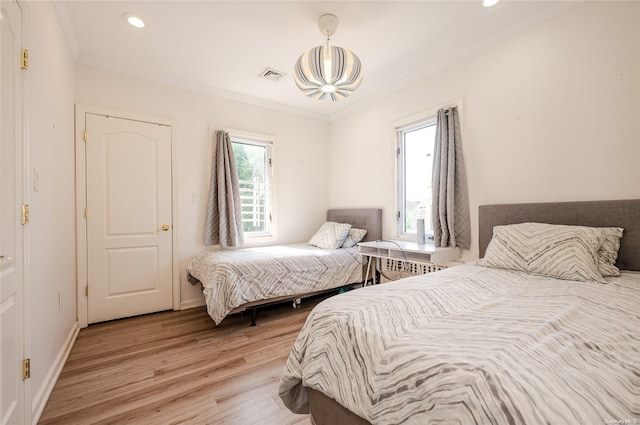 bedroom featuring light hardwood / wood-style floors and ornamental molding